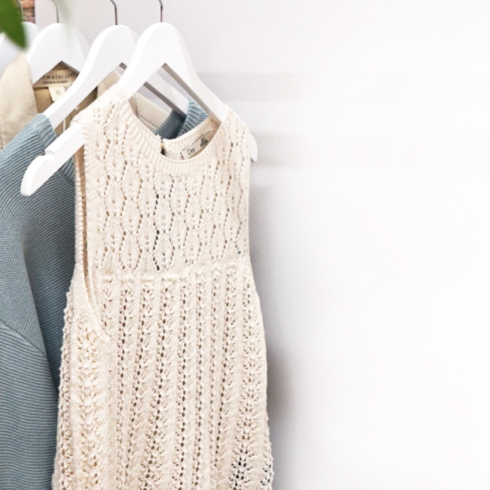 A rack of clothing in front of a white wall